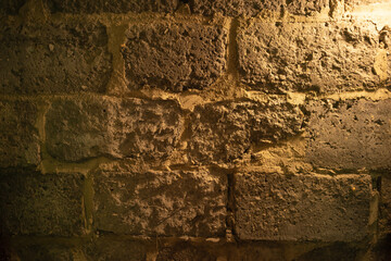 Photo of the texture of a concrete wall in a dungeon. A mystical wall in the basement. The background of the wall of an old castle made of concrete.