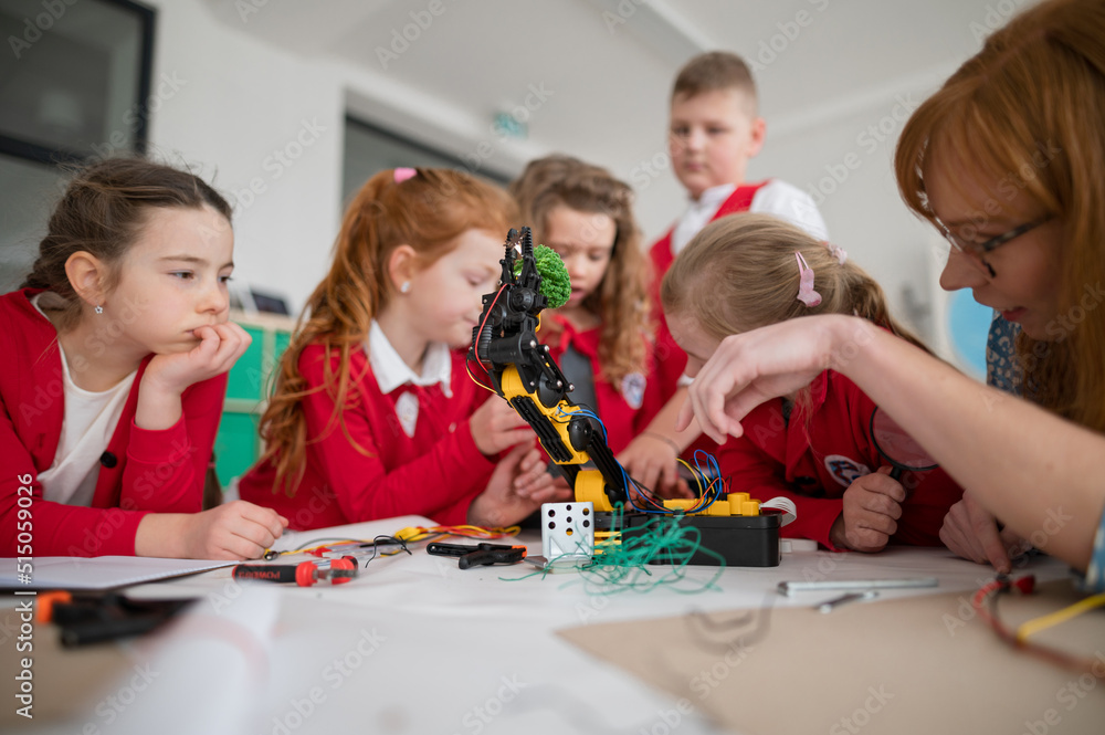 Sticker Group of kids with young science teacher programming electric toys and robots at robotics classroom