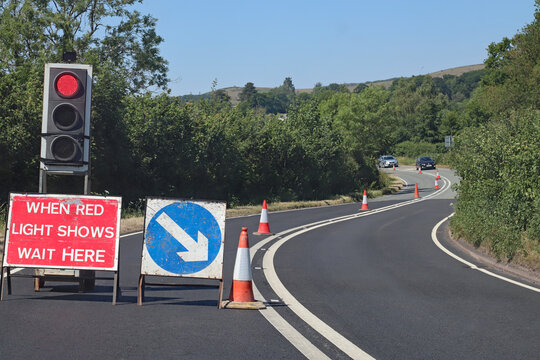 cars approach from the opposite direction at roadworks controlled by traffic lights