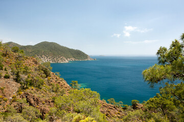 Fototapeta na wymiar Beautiful seascape. View of Mediterranean Sea from a hilltop. Postcard with a view of calm sea in clear weather. Hike along Lycian Way, Antalya, Kemer, Turkey. Spring