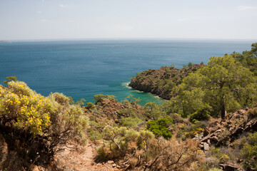 Fototapeta na wymiar Beautiful seascape. View of Mediterranean Sea from a hilltop. Postcard with a view of calm sea in clear weather. Hike along Lycian Way, Antalya, Kemer, Turkey. Spring