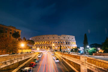 Fototapeta na wymiar Rome, Italy. Colosseum Also Known As Flavian Amphitheatre In Evening Or Night Time. Night Traffic Light Trails Near Famous World Landmark.