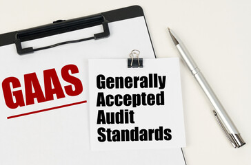 On the tablet, a sheet of paper and stickers with the inscription - GAAS, Generally Accepted Audit...