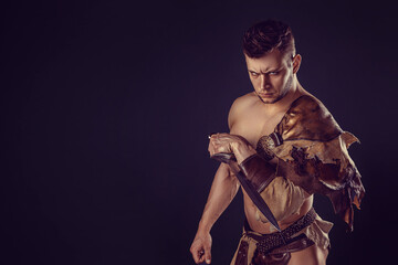 Fototapeta premium Portrait of handsome muscular gladiator with sword. Isolated. Studio shot. 