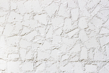 White wall decorated with tiles pieces close-up. Abstract background