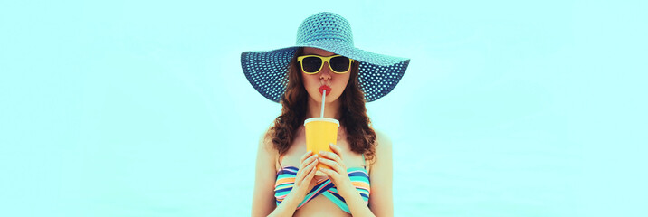 Summer portrait of young woman model drinking fresh juice wearing straw hat on the beach on sea...