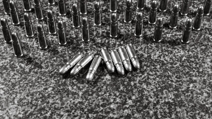 many Tokarev pistol cartridges on a gray granite background - six cartridges are lying in the...