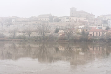 View of the city of Zamora with San Isidoro church and the Douro river in a foogy day.