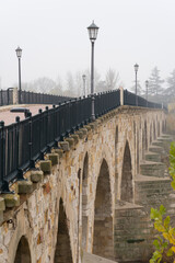 Stone bridge of Zamora and the Douro river in a foogy day.