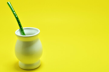 Vaso para mate sobre un fondo amarillo. Espacio para texto al lado derecho. © Cristyan
