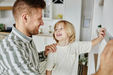 Obraz premium Portrait of loving father and son doing DIY home improvement project together and using level