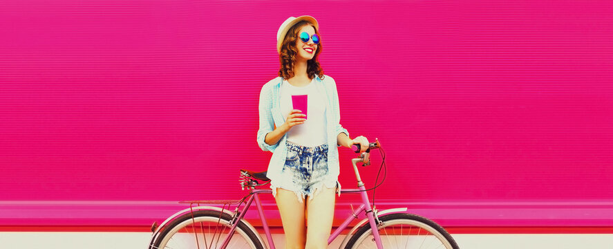 Summer colorful image of happy smiling young woman with bicycle on vivid pink background