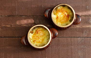 Meat with vegetables and cheese baked in pots Top view.