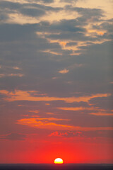 Background of the setting sun outdoors. Sunset colors of the sky. Orange, red, blue and violet shades of the evening sky. Dark, dramatic colors.