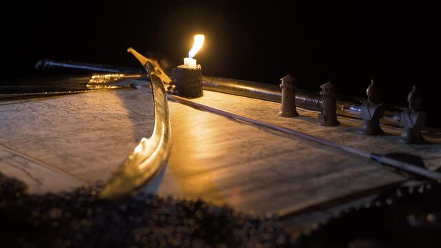 Medieval historical sword. Accompanied by war map and candle.
Plan making on the medieval sword and war map.
