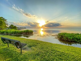 Park bench with view of brilliant sunset at Newton Park on Lake Apopka at Winter Garden, Florida