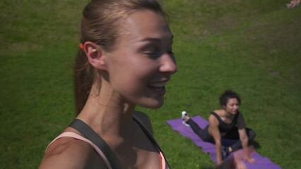 Fit sporty young woman doing yoga exercise giving social media online stream yoga class shooting group training video blog on mobile phone camera. Remote fitness tutorial vlog workout outdoor