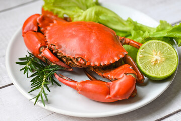seafood plate with herbs spices rosemary lemon lime salad lettuce vegetable, fresh crab on white plate, crab cooking food boiled or steamed crab red in the restaurant