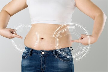 Skinny fat woman figure touches stomach. Abdominal fat and dieting concept. Massaging marks. - obrazy, fototapety, plakaty