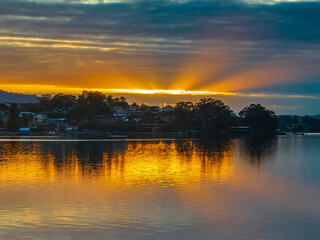 Aerial sunrise waterscape with boats, reflections and cloud filled sky