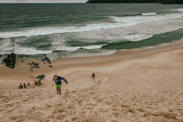 Kids climbing large sand dune near the beach at Forster, NSW Australia