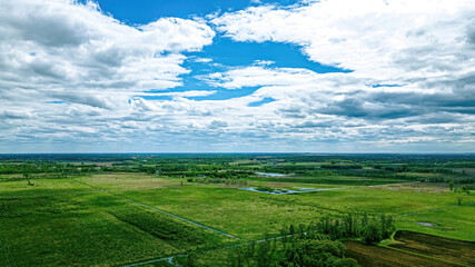 Clouds floating over a grassy green landscape