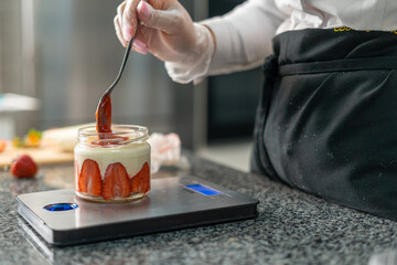 Obraz premium young girl chef makes desserts. bakes sweets and cakes. makes blanks and prepares fruits for the filling. baking, dessert, sweets, complex cooking processes.