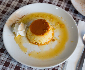 Tasty dessert flan with caramel on top served with whipped cream