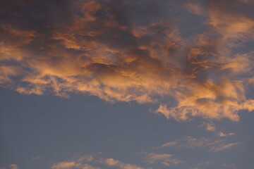 Zerfetzte Haufenwolke zur blauen Stunde. Die Sonne ist bereits untergegangen. Die letzten Strahlen wärmen nur den Himmel. Die Wolken tanzen gemächlich im alten Licht. Der Tag geht. Die Nacht kommt. 