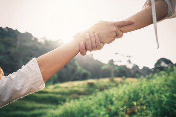 Helping hand outstretched for salvation . Strong hold. Couple hiking help each other in mountains . Two people climbing on mountain and helping.