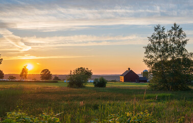 sunrise over the farm with barn and hay bales - Powered by Adobe