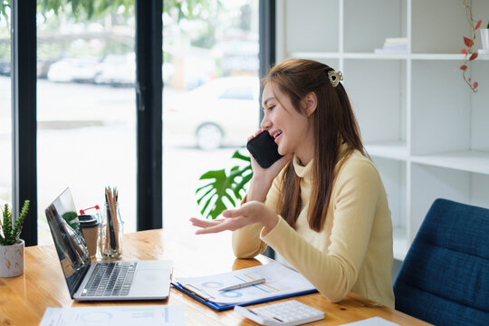 Image of Young woman with a cell phone working online on laptop computer. studying or working from home online concept.