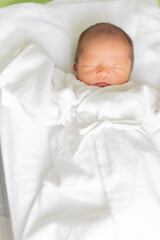 ベッドで眠る赤ちゃん　新生児