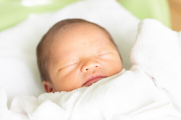 ベッドで眠る赤ちゃん　新生児