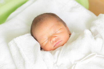 ベッドで眠る赤ちゃん　新生児