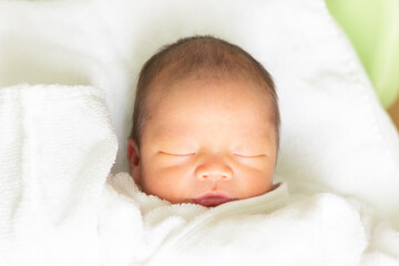 ベッドで眠る赤ちゃん　新生児