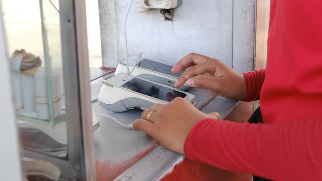 A Pertamina employee holds a digital program at a Pertamina gas station. Payment system with app