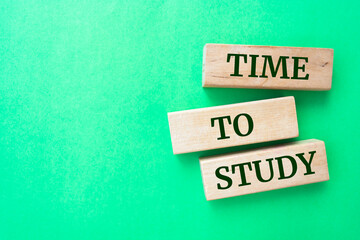 Time to study words on wooden blocks on green background.