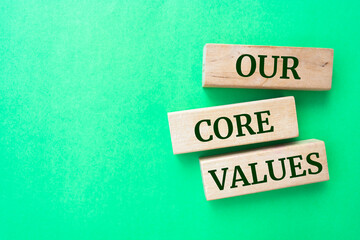 Our core values words on wooden blocks on green background.