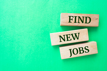 Find New Jobs words on wooden blocks on green background.