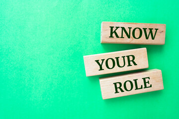 Know Your Role words on wooden blocks on green background.