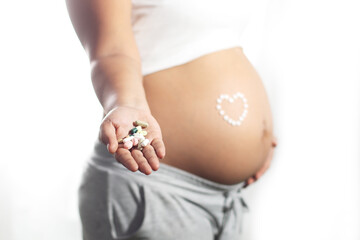 Pregnant woman latina with pills on right hand, white background
