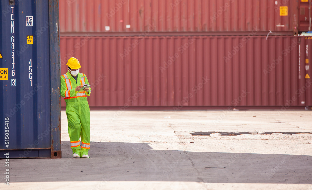 Poster engineer wearing uniform inspection and see detail on tablet with logistics container dock cargo yar