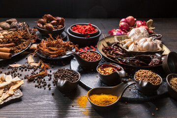 Set of spices for cooking various dishes Placed on a wooden floor. Dark tone style.