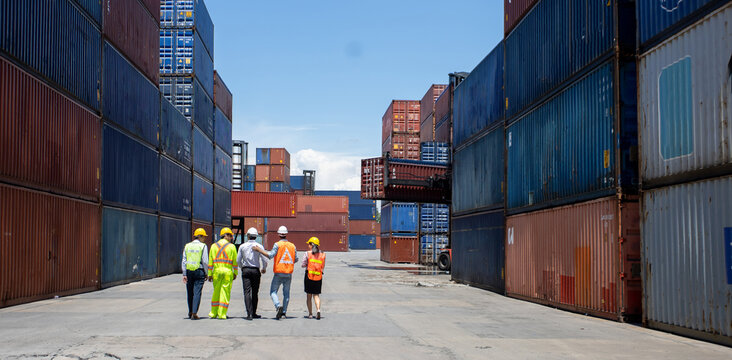 Group Workers People In Safety Uniforms And Hard Hats Work At Logistics Terminal With Many Stacks Of Containers ,Engineer Dock Worker Wear Safety Uniform Check Control Loading Freight Cargo Container