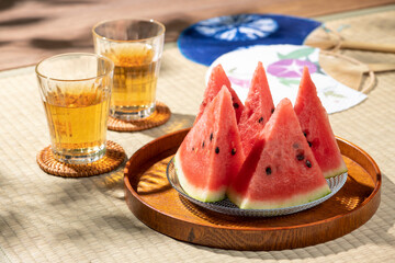 縁側のある和室の畳にスイカと麦茶とうちわ、日本の夏風景