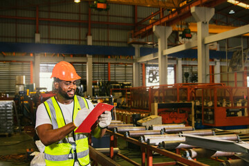 African American workers wearing helmets and reflective vests walk holding clipboards reading sheet metal sheet coil material inspection reports at sheet metal roofing factories.