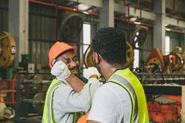 Happy good friendship solidarity between two african american male industrial workers crossing their arms greetings show respect and recognition of your abilities and goodwill towards your coworkers.