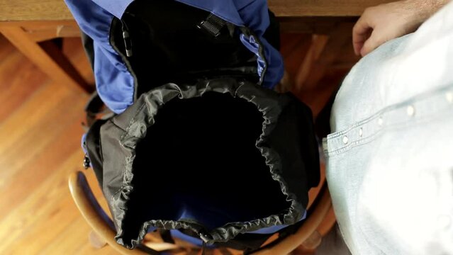 Close up shot of hands opening backpack for travelling - top view