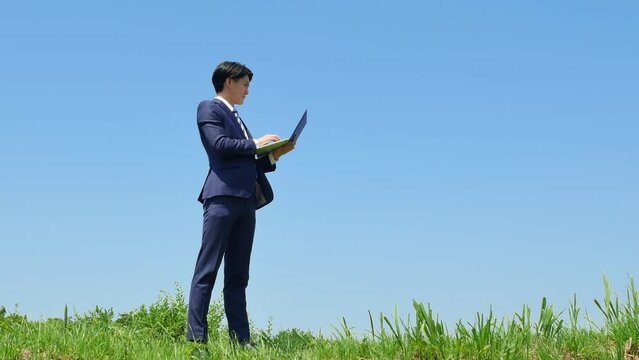 屋外でノートパソコンを使うビジネスマン